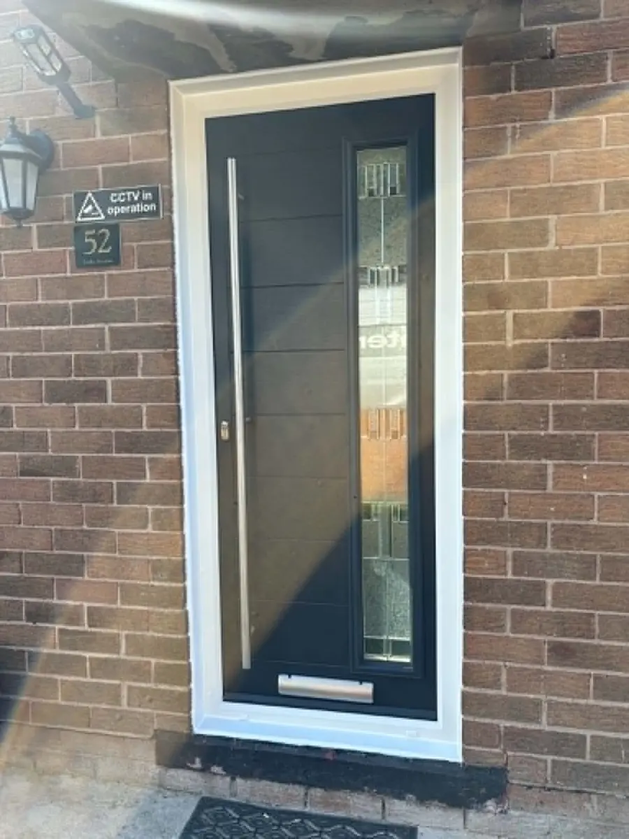 Black composite door fitted in a brick property